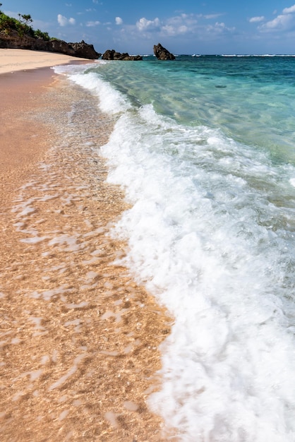 Foto onda quebrando ao longo da espuma branca da costa