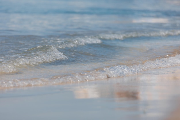 Onda suave do mar azul na praia de areia Foco seletivo de fundo