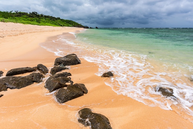 Onda suave do mar verde aqua sobre areias claras e rochas incríveis em um paraíso de praia