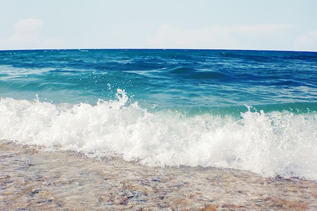 Onda suave del océano azul en el fondo de la playa de arena