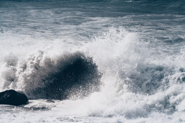 Foto ondas a salpicar no mar contra o céu