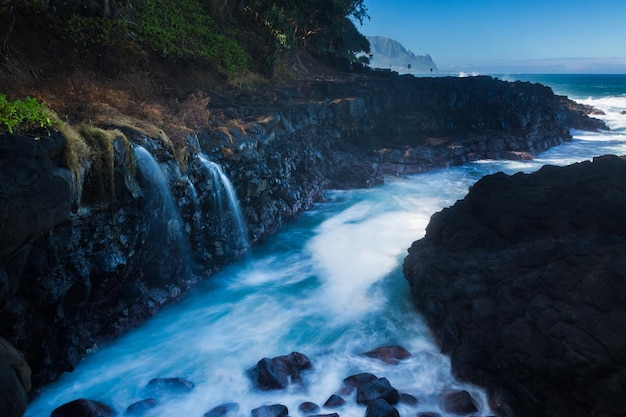 Ondas atingem rochas no Queens Bath Kauai