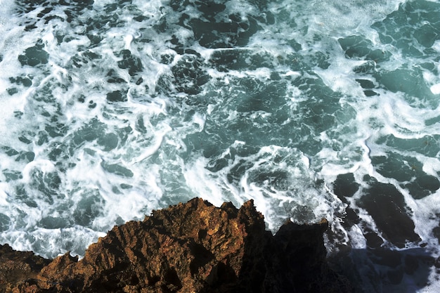 Ondas azuis atingindo altos penhascos