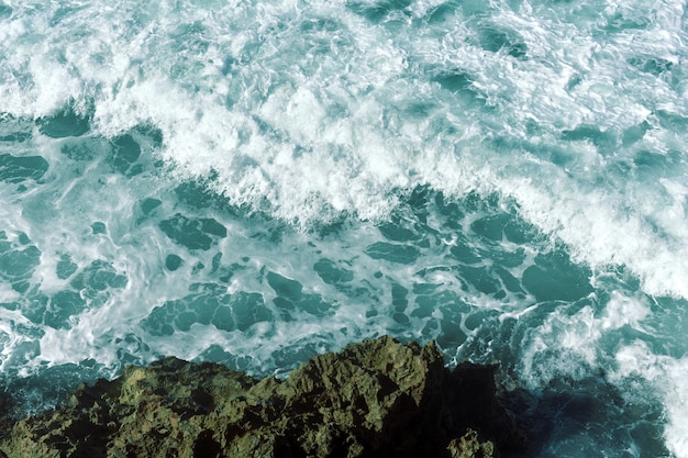 Ondas azuis atingindo altos penhascos