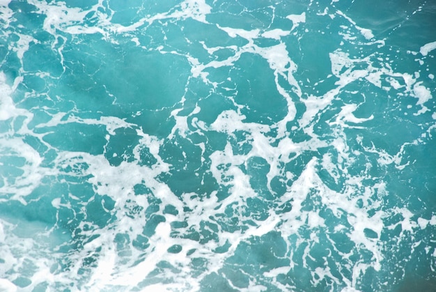 Las ondas azules del agua contra el fondo de las olas del océano