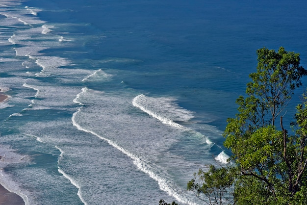 Foto ondas batendo na praia, com mar azul, no litoral norte de são paulo. são sebastião, sp, brasil