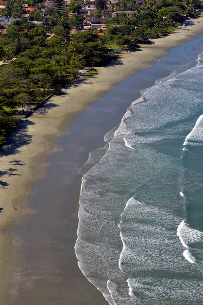 Ondas batendo na praia, com mar azul, no litoral norte de São Paulo. São Sebastião, SP, Brasil