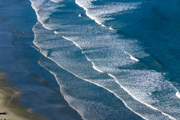 Ondas batendo na praia, com mar azul, no litoral norte de são paulo. são sebastião, sp, brasil