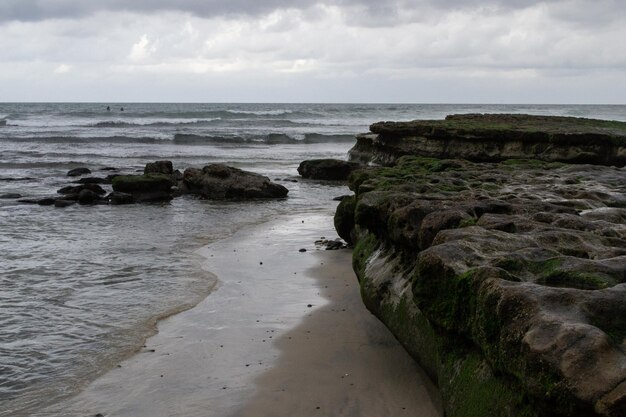 Ondas de la costa de la orilla de la playa nublada