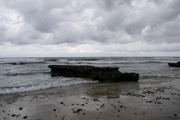 Ondas de la costa de la orilla de la playa nublada