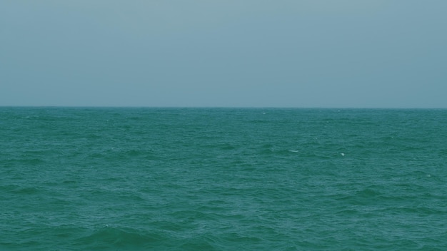 Ondas de espuma de água sobem e quebram na costa formando espuma vitalidade de energia azul e água cristalina do oceano