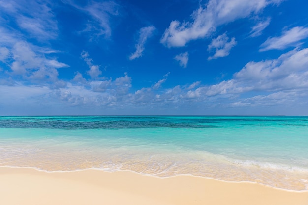 Ondas de praia de areia closeup e céu azul de verão. Paisagem panorâmica da praia. Cena de praia tropical vazia