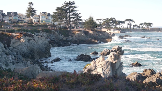 Ondas de praia do oceano rochoso batendo casas à beira-mar na costa de monterey califórnia