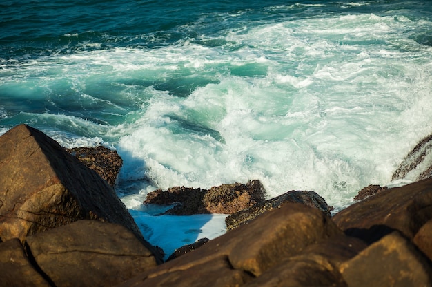 Foto ondas do mar batendo contra o fundo das rochas