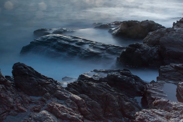 Ondas do mar batendo nas rochas no por do sol