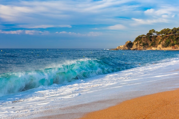 Ondas do mar e praia principal de areia no popular resort de férias lloret de mar na costa brava pela manhã