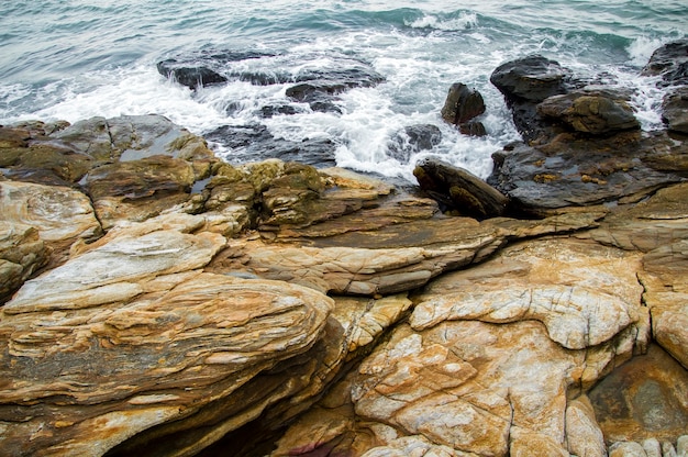 Ondas do mar quebrando nas rochas com salpicos