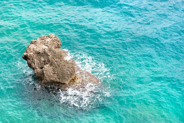 Ondas do mar quebrando nas rochas com salpicos