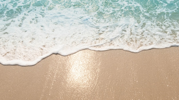 Foto ondas do oceano azul luz solar reflexo fundo da areia da praia