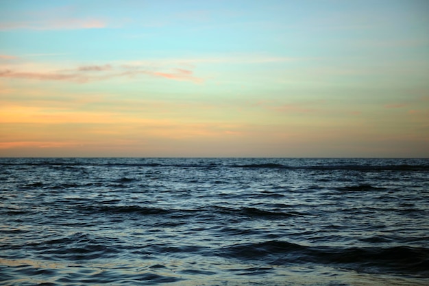 Ondas dramáticas do oceano vermelho ao pôr do sol com água escura do mar suave à noite