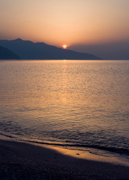 Ondas e belo pôr do sol na ilha grega Evia Euboea no mar Egeu
