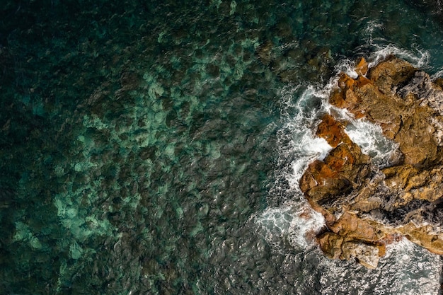 Ondas espumosas quebrando na costa rochosa