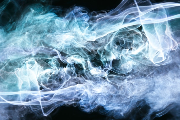 Foto ondas de humo azul sobre fondo negro