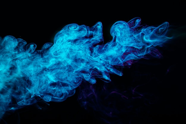 Foto ondas de humo azul sobre fondo negro