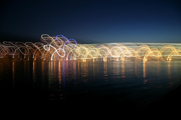 Las ondas de iluminación de colores abstractos en el reflejo sobre el agua