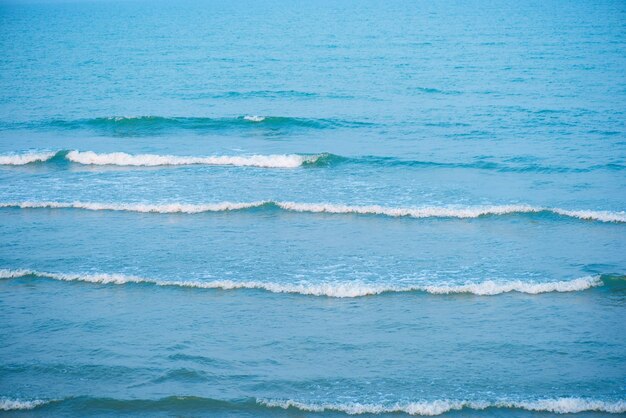 Ondas na praia Ondas do mar azuis Textura da superfície da água azul com ondulações salpicos e bolhas