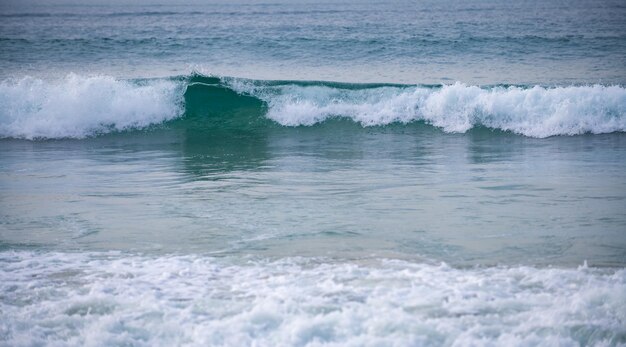 Ondas oceânicas de praia de verão em um mar tropical com wawes azuis profundos Fundo do oceano do mar calmo