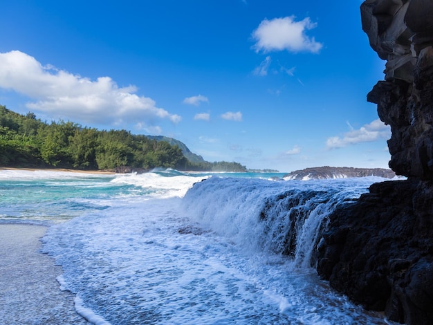 Ondas poderosas fluem sobre rochas em lumahai beach kauai