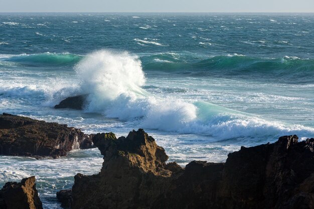 Ondas quebrando na costa rochosa. Vista do mar à noite da costa.