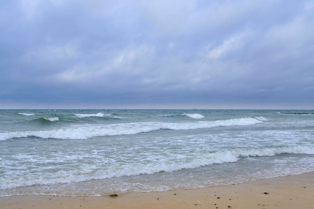 Ondas rolantes na praia de areia do Mar Báltico