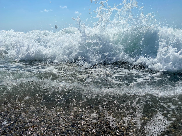 Ondas salpicam de água na praia no mar de férias em um turista tropical oriental quente