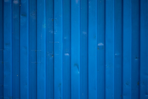 La ondulación azul de la pared del contenedor parece ondas en la textura del techo de zinc.