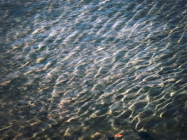 Ondulaciones en la superficie del agua. Fondo del lago de montaña.