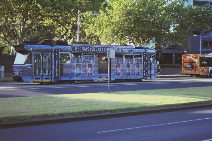 Foto ônibus com texto estacionado na estrada contra árvores