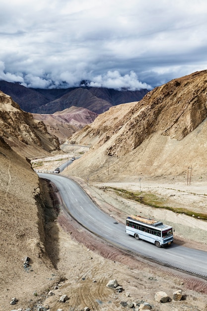 Ônibus indiano de passageiros na estrada no himalaia. ladakh, índia