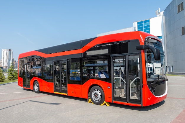 Foto Ônibus urbano moderno vermelho na estação rodoviária em um dia claro