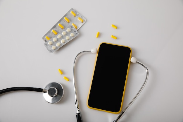 Online-Arztkonsultationskonzept Stethoskop und Smartphone auf einer weißen Tischplatteansicht