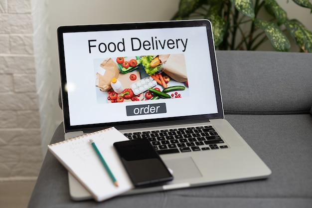 Online-Bestellung von Lebensmitteln: Frau mit einem Laptop, der eine Fast-Food-Website auf dem Bildschirm zeigt. Bildschirmgrafiken werden erstellt.