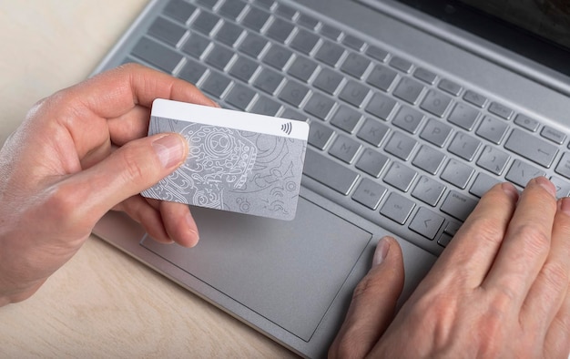 Online bezahlen mit Bankkarte und Laptop aus nächster Nähe