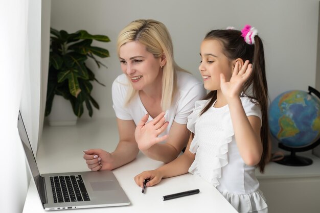 Online-Bildung von Kindern. Mutter und Tochter der Vorschule beobachten zu Hause einen Videolektion-Chat.