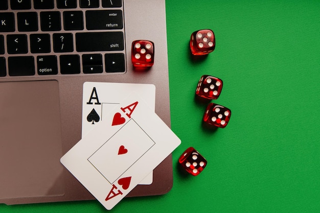 Online-Casino-Thema mit Spielkarten und roten Würfeln auf einem Laptop