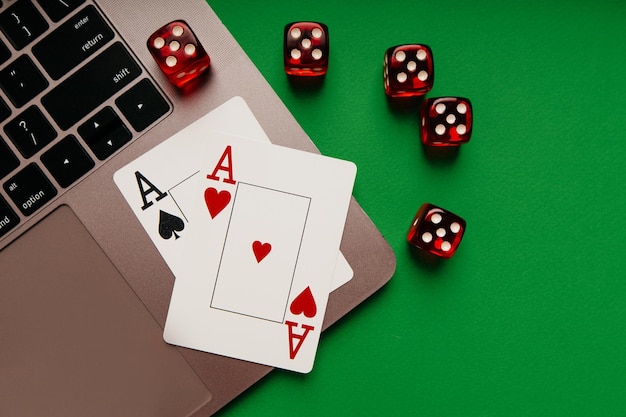 Online-Casino-Thema mit Spielkarten und roten Würfeln auf einer Laptop-Draufsicht