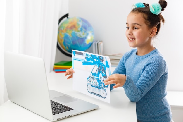 Online-Fernstudium zu Hause während der Quarantäne. kleines Mädchen lernt Logik auf Laptop online