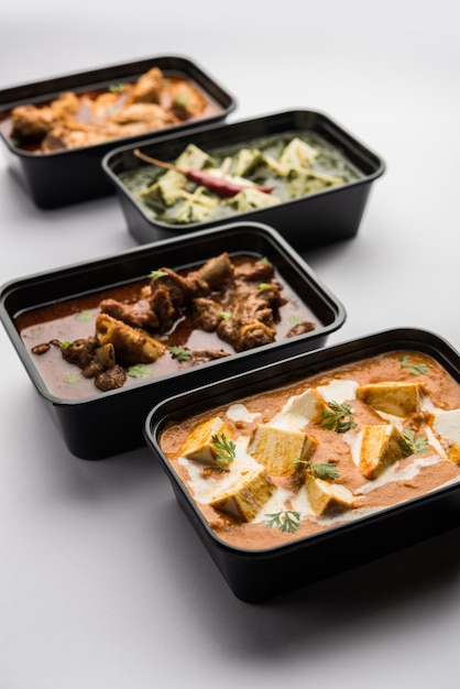 Online-Lebensmittellieferkonzept Indischer Paneer Butter Masala und Palak Paneer, Hammel- und Hühnchen-Curry mit Roti und Reis in Plastikbehältern, Lebensmittel wie Butterhuhn, Hühnchen