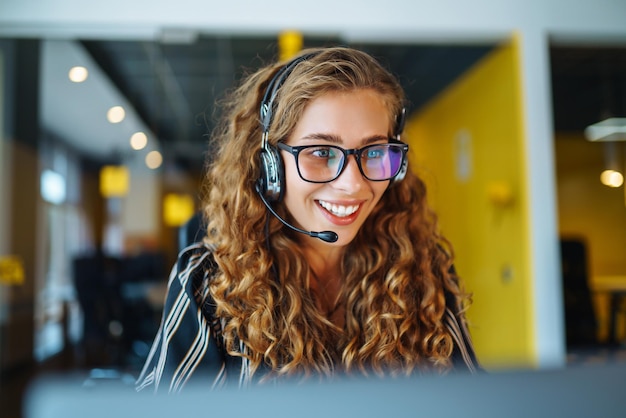 Online-Meeting Junge Frau mit Kopfhörern und Laptop, die sich ein Webinar ansieht oder einen Video-Chat macht