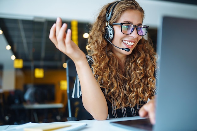 Online-Meeting Junge Frau mit Kopfhörern und Laptop, die sich ein Webinar ansieht oder einen Video-Chat macht